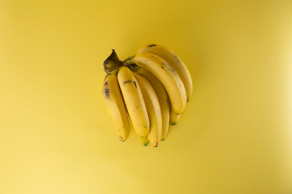 Um cacho de banana em um fundo amarelo.